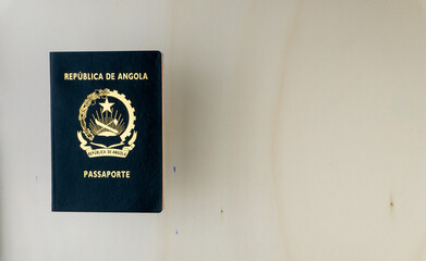 Overhead shot of Angolan passport isolated on wooden table.