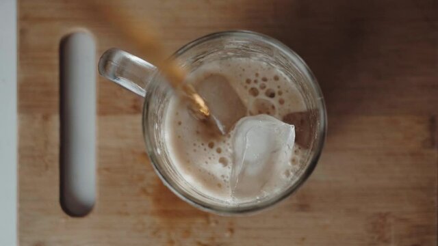 Sirviendo refresco de cola en un vaso con hielo. 