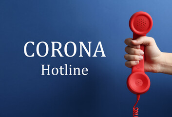 Covid-19 Hotline. Woman with red handset and text on blue background, closeup