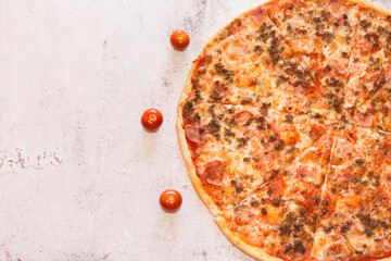 Tomatoes around a pizza. Pizza on rustic and white texture