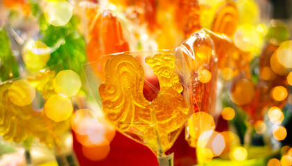 Sugar lollipops at Christmas market. Cockerel candy on a stick. Hard candy rooster. Sweet caramel...