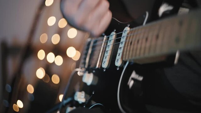 Chico latino toca la guitarra el&eacute;ctrica en su casa durante la cuarentena
