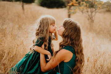 Mom hugs and laughs with her daughter in nature