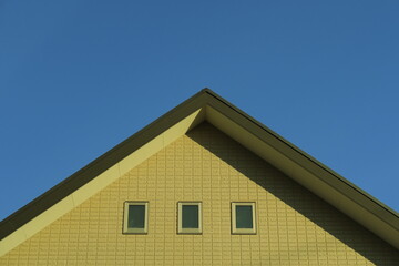 冬の西日の当たる新築住宅の壁と屋根と青空