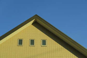冬の西日の当たる新築住宅の壁と屋根と青空