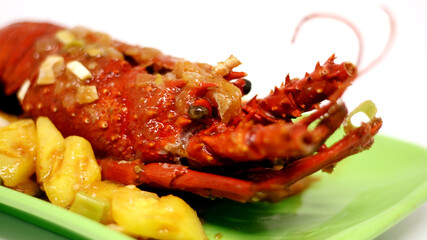 Sweet and sour lobster on green plate. Indonesian food.