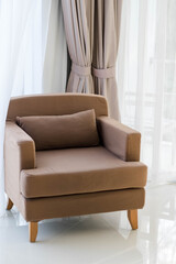 A brown sofa in a clean room bathed in light.
