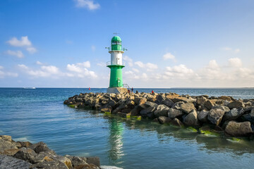 The green and white lighthouse at the mouth of the Baltic Sea atWarnemunde Rostock Germany harbor...