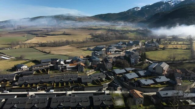 Aerial view of the little village of Bor in La Cerdanya, with the snowy mountains behind