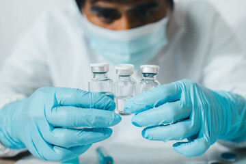The concept of fighting the coronavirus, the COVID-19 doctor carries a liquid vaccine for the sick.
