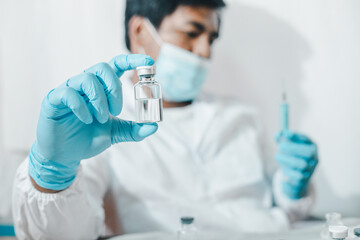 The concept of combating the coronavirus, the novel coronavirus, a doctor or scientist in a laboratory holds a vaccine.
