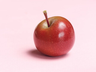 Cute red apple isolated on pink background, studio shot.