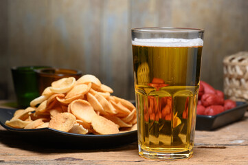 Glass of cold light beer with snacks