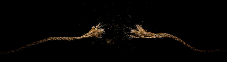 Long dirty rope, frayed at both ends and snapped in two. Concept of dangerous stress or stressful situation like divorce separation, deadlines, failure, or tension. © Leigh Prather