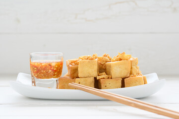 Deep fried tofu is cut into square balls on plate