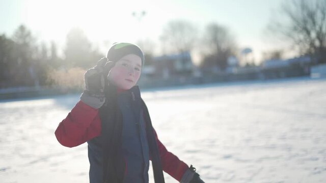 Slow-motion Shot Of A Child In A Red Snowsuit Giving The Peace Sign.