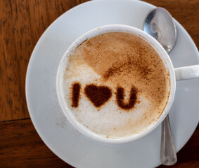 Top view of a cup of hot coffee cappuccino, latte decorated with heart art I love you message.