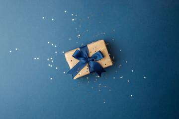 Happy Fathers Day concept - stylish craft gift box with bow on classic blue background, holiday,...