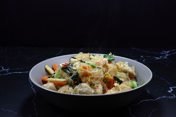 Classic Fried and stirred fresh vermicelli noodle with tofu, carrot, chilly and spring onion seasoning with pepper and soy sauce. Famous spicy street food menu in Asia. 