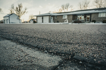 low angle selective focus on asphalt overlay paving on top of a concrete base of a residential...