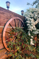Wagon Wheel on a Fence with Floral Around It
