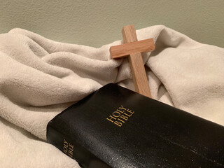 Wooden Cross Set Behind a Bible on a Blanket