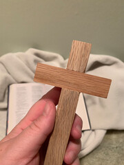 Wooden Cross Held Over an Open Bible