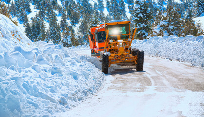 The bulldozer cleans snow on the road