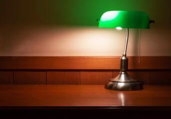 vintage lamp with green shade on wooden desk
