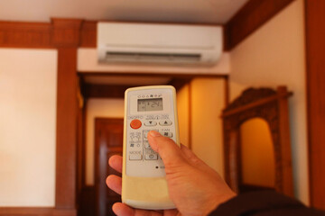 hand holding air conditioner remote controller