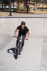 Obraz premium Latin man on bicycle in urban park. outdoor activity concept