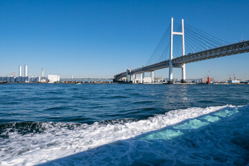 Fototapeta na wymiar 日本の横浜にあるベイブリッジ。海から見た青い空と橋の風景。
