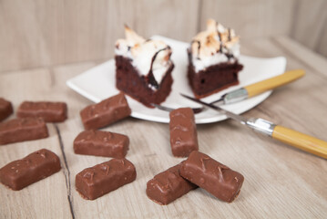 Delicious chocolate candies with cake on a wooden background.