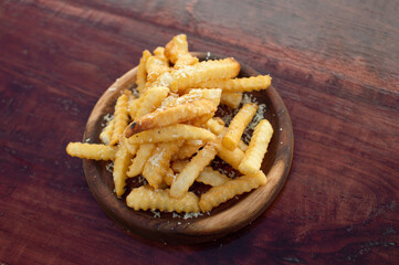 french fries with parmesan cheese on wooden board