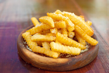 french fries with parmesan cheese on wooden board