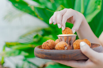 beautiful woman holding crispy fast food dipping in cheese sauce