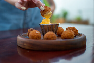 beautiful woman holding crispy fast food dipping in cheese sauce
