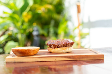 preparation of burger on wooden board and sauce