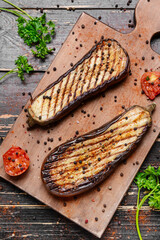 Tasty grilled eggplant with spices on wooden background