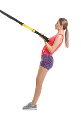 Sporty young woman training with TRX straps on white background