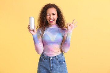 Beautiful African-American woman with soda showing OK on color background