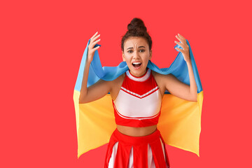 Emotional cheerleader with the flag of Ukraine on color background