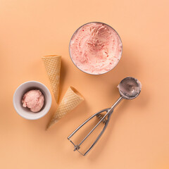 Homemade yogurt strawberry ice cream, sweet waffle cones on pastel pink background.
