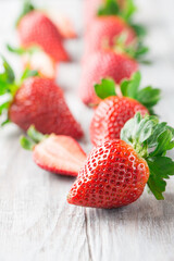 Juicy fresh strawberries on old white wooden background.
