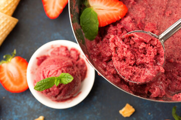 Homemade Fruit strawberry sorbet with mint in a bowl on wooden table, top view.