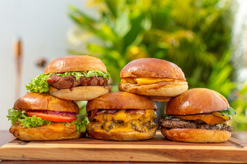 five delicious hamburgers with extra meat and cheese on wooden boards fast food