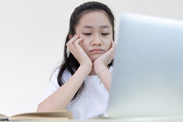 Asian girl are bored with the homework that teachers order online,Despair or disappointment, Feel sad, Failure of life, New normal, Covid-19 coronavirus, Social distancing, Internet learning...