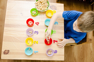 Little child doing simple math exercises. Early education, counting game. Preschool exercise for...
