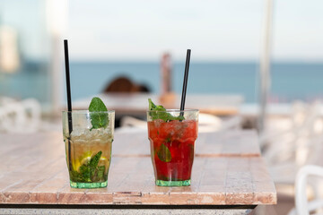 Appetizing cocktails on a wooden table outdoors