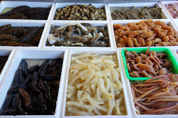 Various type of seafood like sea cucumber, squid, octopus, seaweed on the market stall
